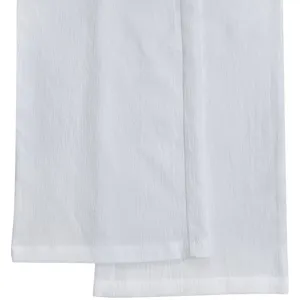 White crinkled fabric detail of trousers, soft texture and neat stitching, close-up view.