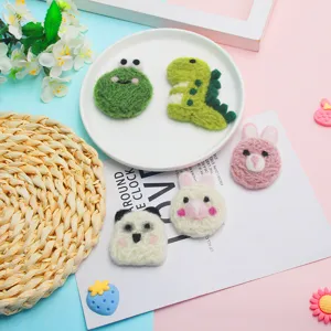 Cute wool felt animal accessories detail showing frog, dinosaur, rabbit and panda designs.