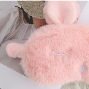 Close-up of pink plush bunny eye mask with cute closed-eye embroidery, soft sleep accessory.