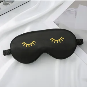 Black silk sleep mask with gold eyelashes detail, soft eye cover for better sleep quality.