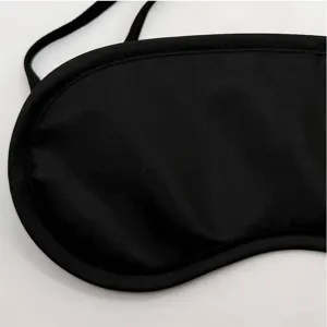 Détail en gros plan d'un masque de sommeil occultant noir, tissu doux et respirant avec sangle.