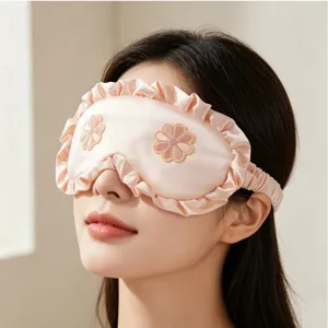 Máscara de dormir de seda con volantes y flores bordadas para un sueño cómodo.