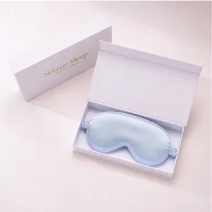 Close-up detail of the light blue silk sleep mask in an elegant white gift box set.