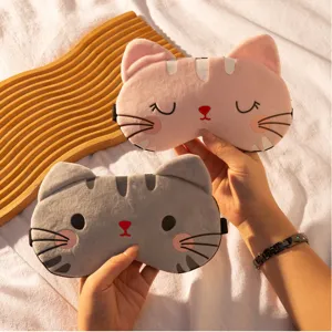 Primo piano dettagliato di maschere da notte in peluche di gatto rosa e grigio con tessuto.