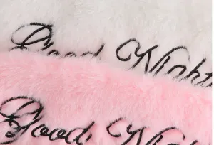 Plüsch Schlafmaske Detail mit weichem Kunstkaninchenfell und süßer gestickter Good Night Schrift.