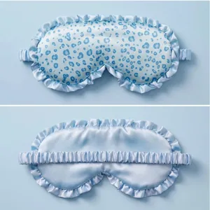 Close-up detail of blue leopard print sleep mask with soft ruffle edge and satin finish.