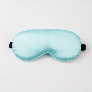 Close-up detail of smooth light blue silk sleep mask with adjustable black elastic strap.