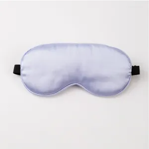 Close-up detail of the smooth silk eye mask texture, soft fabric surface with elastic strap.