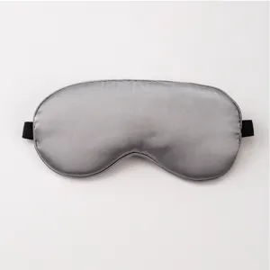 Grey silk sleep mask detail showing smooth satin texture and black elastic band for sleeping.