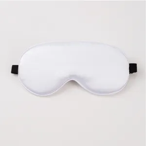 Close-up detail of white silk sleep mask, soft smooth fabric surface, elastic black strap.