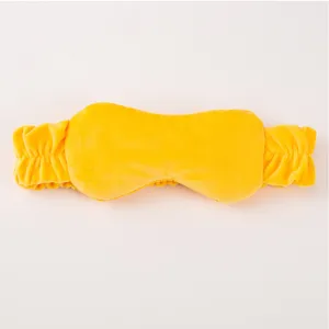 Close-up detail of soft yellow plush 2-in-1 headband and sleep eye mask, cozy fabric texture.