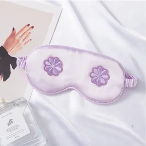 Close-up detail of imitation silk sleep mask with exquisite 3D floral embroidery design.