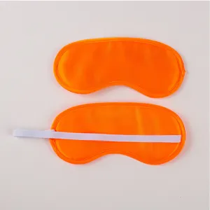 Orange satin eye mask detail showing smooth fabric texture and elastic back strap design.