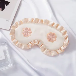Antifaz de satén para dormir con volantes y flores bordadas, suave y cómodo para el descanso.