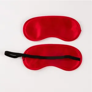 Detailed view of the red satin sleep eye mask, showing smooth fabric texture and elastic band.