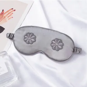 Grey silk sleep mask with floral embroidery, breathable eye cover for travel and home sleep.