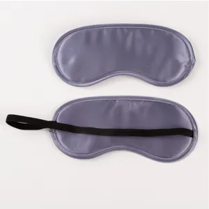 Close-up detail of solid color satin sleep mask, soft fabric texture and elastic back strap.