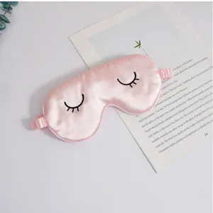 Nahaufnahme der rosa Seidenschlafmaske mit feinen bestickten Wimpern und weichem Gummiband.
