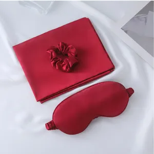 Red silk sleep mask pillowcase and hair scrunchie 3-piece set for comfortable travel rest.