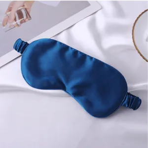 Gros plan sur le masque de sommeil en soie bleue lisse, texture douce pour un repos parfait.