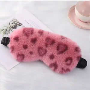 Dettaglio maschera da notte in peluche rosa, motivo cuori leopardati, morbida e comoda.