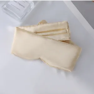 Vista detallada del antifaz para dormir de seda sintetica champagne, textura suave y comoda.