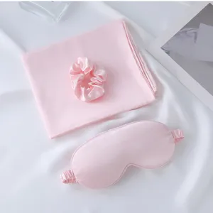 Pink satin sleep mask, scrunchie, and pillowcase detail view, soft fabric for smooth comfort.