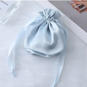 Primo piano del sacchetto con coulisse in raso azzurro, tessuto liscio per confezioni regalo.