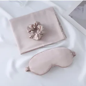 Silk satin sleep eye mask pillowcase and scrunchie detail shot in elegant light pink tone.
