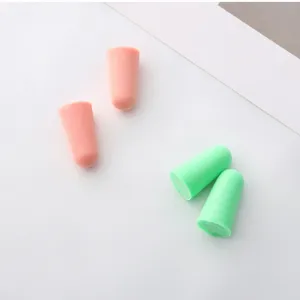 Detail shot of soft slow rebound memory foam earplugs in pink and green colors, noise reduction.