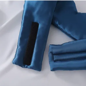 Detalle de antifaz de satén azul con textura de tela suave y cierre de velcro seguro.