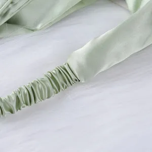 Hellgrüne Satin elastische Stirnband Nahaufnahme, minimalistisches Haar-Accessoire Alltag.