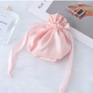 Vista dettagliata della borsa regalo con coulisse in raso rosa, elegante custodia morbida.