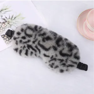 Close up of grey leopard plush sleep mask detail showing soft furry texture and elastic strap.