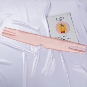 Mascarilla de dormir de seda rosa con pestanas bordadas y velcro para descanso comodo.