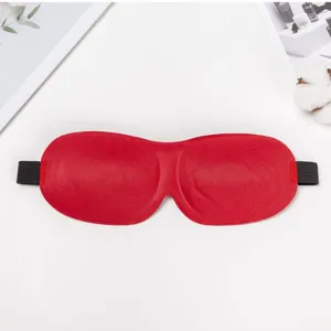 Detail shot of a red 3D contoured sleep mask with black elastic strap for travel rest.