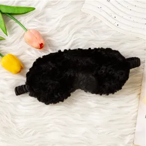 Primo piano della maschera da notte in peluche nera con trama morbida e fascia elastica.