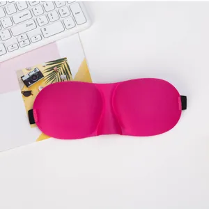 Close-up detail of a bright pink 3D contoured sleep mask with soft padding and elastic strap.