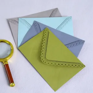 Colored laser cut lace triangular envelopes for wedding invitations, birthday cards and stationery.