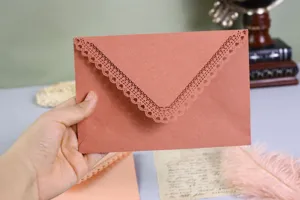 Laser cut lace paper envelope detail, elegant hollow heart design for wedding and party invitation.