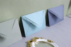 Laser cut lace colored hollow triangular envelopes for wedding party invitations detail shot.