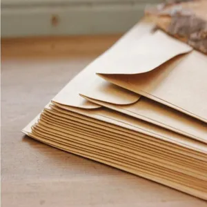 Plain brown kraft paper envelopes stack, vintage style stationery cards storage detail shot.
