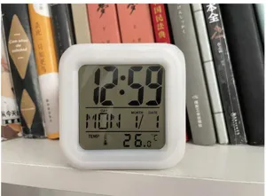 Square digital alarm clock with color changing LED light, temperature and time display.