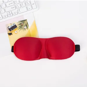 Close-up detail of the 3d contoured sleep eye mask in vibrant red with elastic band.