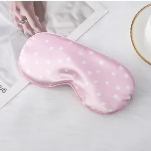 Detailed view of the pink star-printed silk sleep mask, soft texture close-up for night.