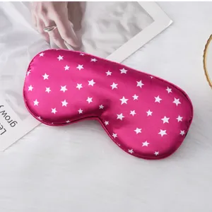 Detailed view of pink silk sleep mask with white star print for sleeping and travel.