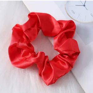 Detalle de coletero de saten rojo, accesorio para el cabello de seda suave y elegante.