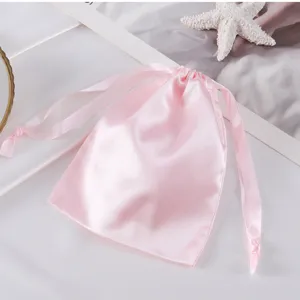 Nahaufnahme eines rosa Satin-Kordelzugsacks, ideal zur Schmuck- und Kosmetikaufbewahrung.