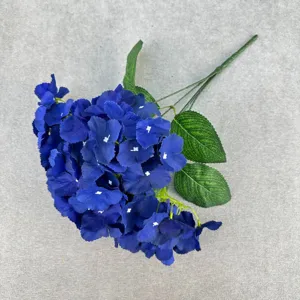 Close-up detail of artificial blue hydrangea flower, showing realistic petals and leaves.
