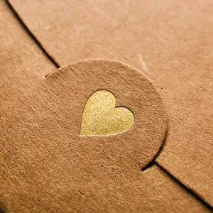 Brown craft paper envelope featuring a luxury gold foil heart seal for romantic letters and cards.